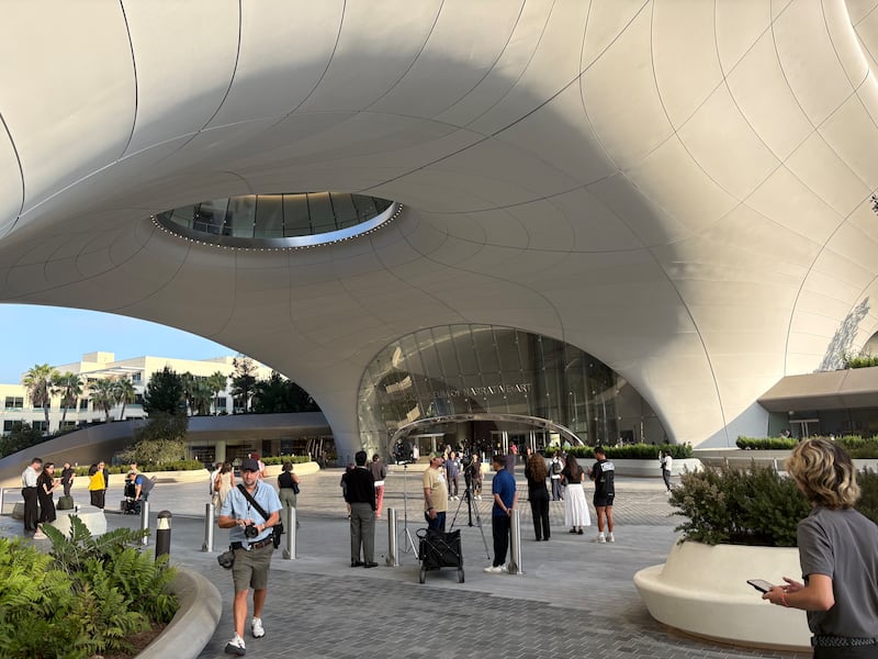 Photo of outside of the museum entrance and people waiting outside.