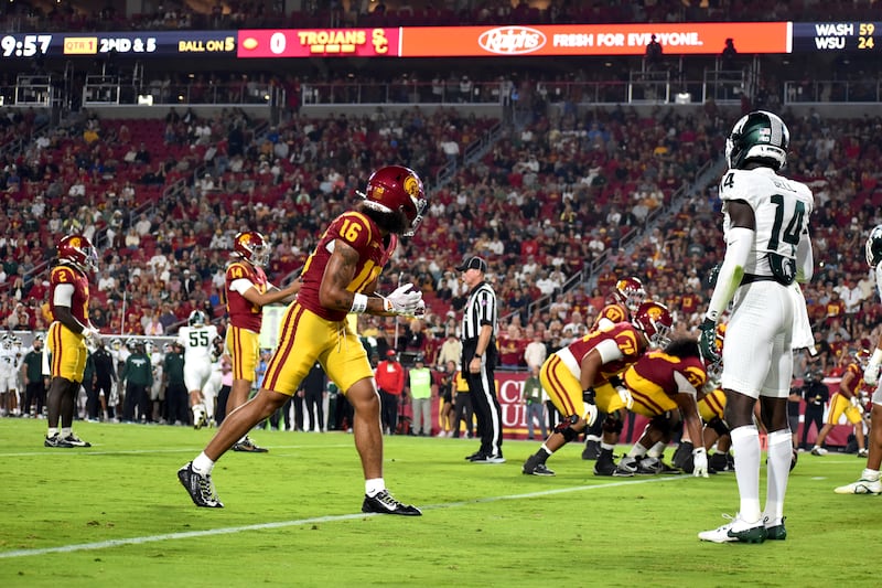 Tanook Hines (16) lines up against a Michigan State defender. The rest of the team can be seen at the line of scrimmage in the background.