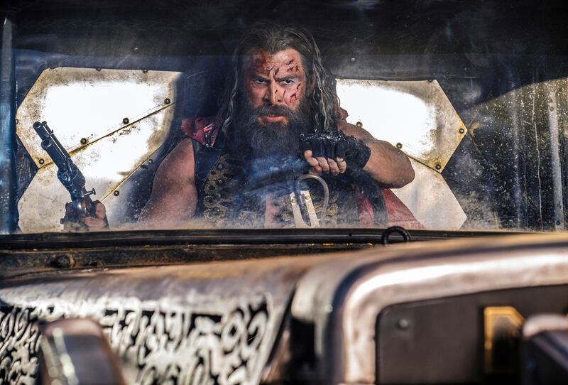 Photo of a man with a beard and gun in a truck
