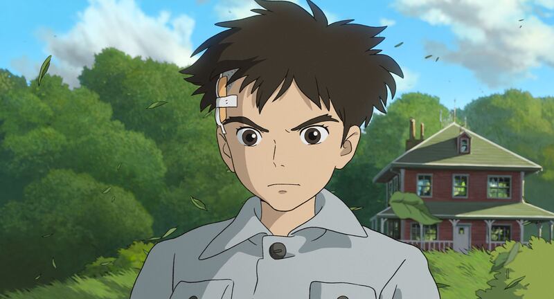 Film screenshot of a boy in front of a house