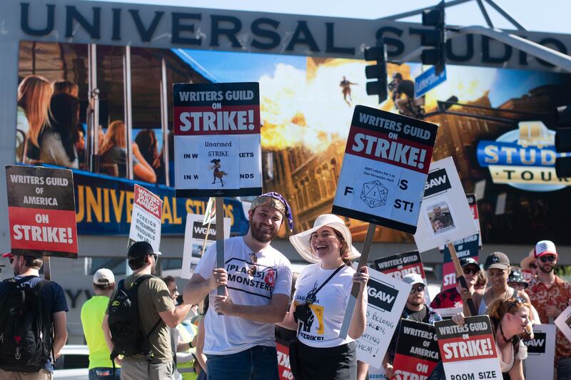 A couple striking together in front of the Universal Studios sign.