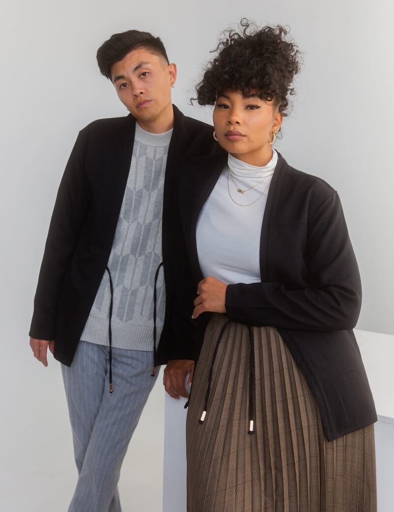 Two models stand together with black jackets