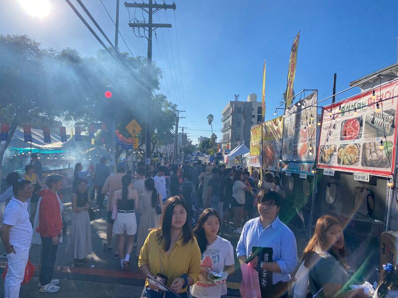 Photo of a crowd walking past food stands