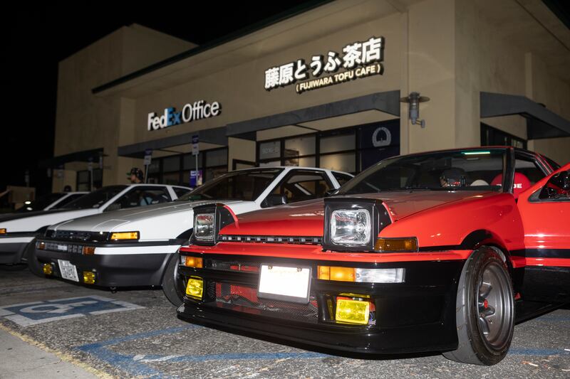 Red car next to white cars