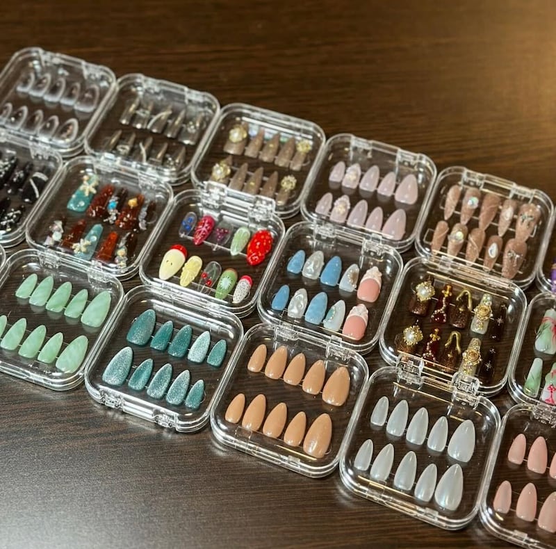 Several sets of press-on nails, ranging from sparkly green to 3D nails.