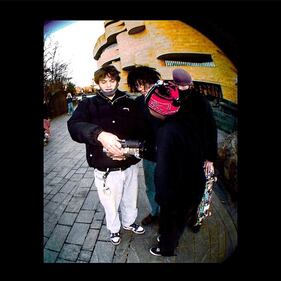 Photo of three friends looking at a video camera.