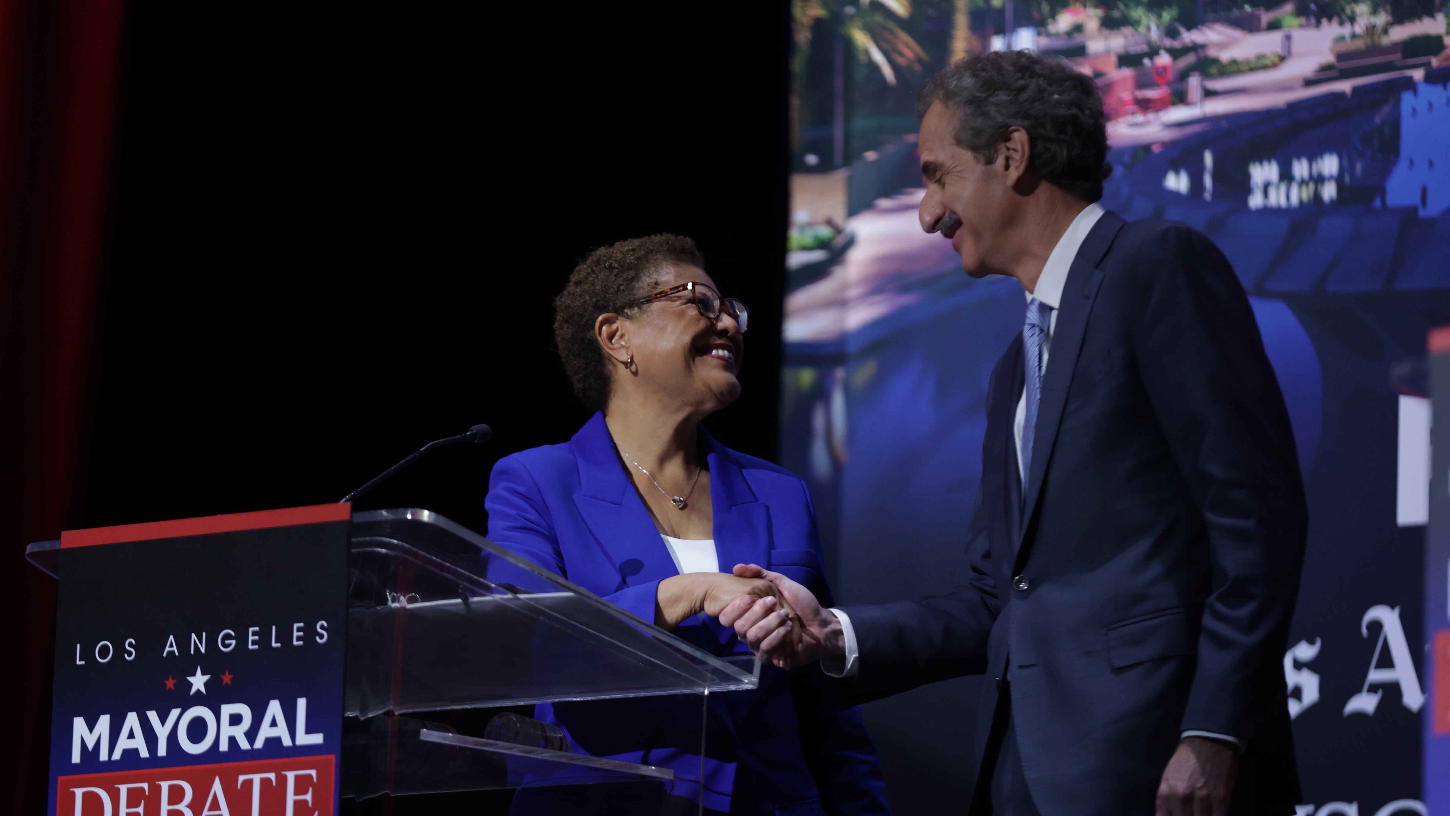 Karen Bass and Mike Feuer shake hands and smile at one another at mayoral debate.