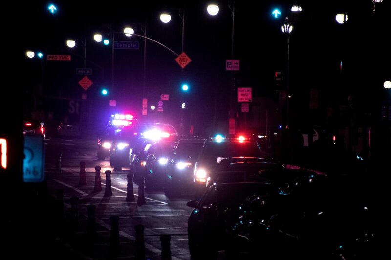 [Photo of LAPD squad cars lit up at night.]