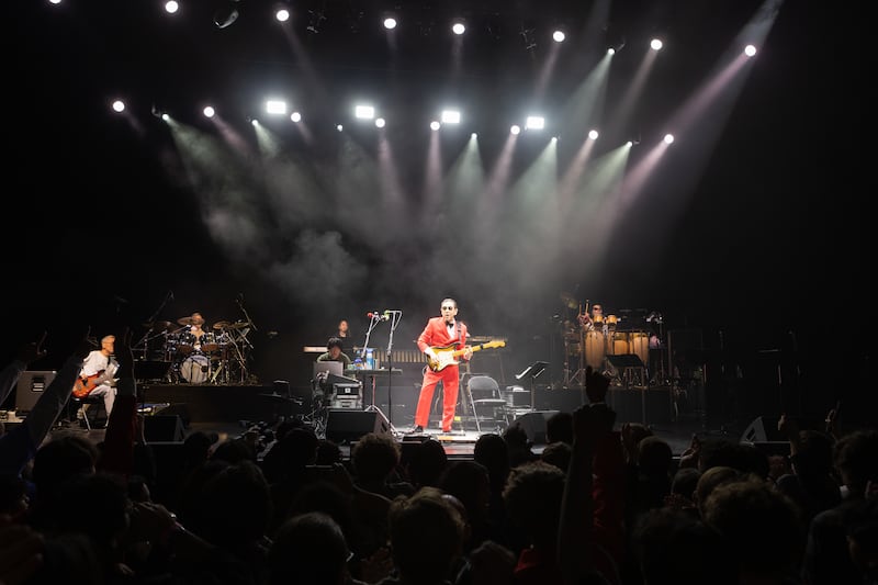 Photo of spotlights shining on a man playing the guitar
