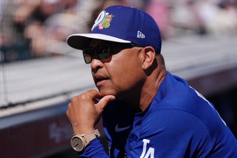 Photo of a man in a blue shirt with his hand on his chin.