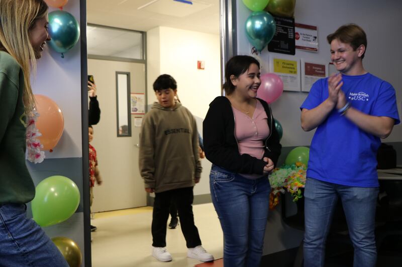 A photo of Tess reacting in a surprised way as she walks into the door of the surprise party.