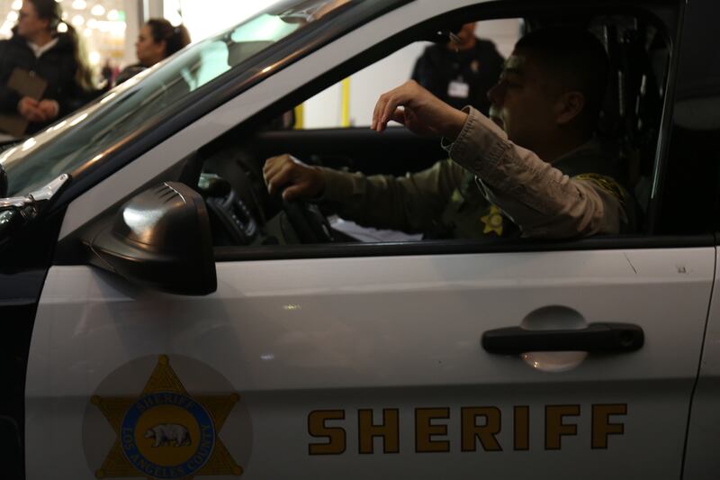 An L.A county sheriff arrives to drop off ballots at the processing center on the night of March 5, 2024.
