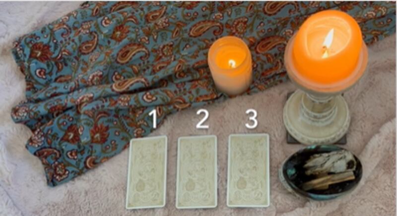 Weekly card reading session conducted in a candlelit corner of a college apartment.