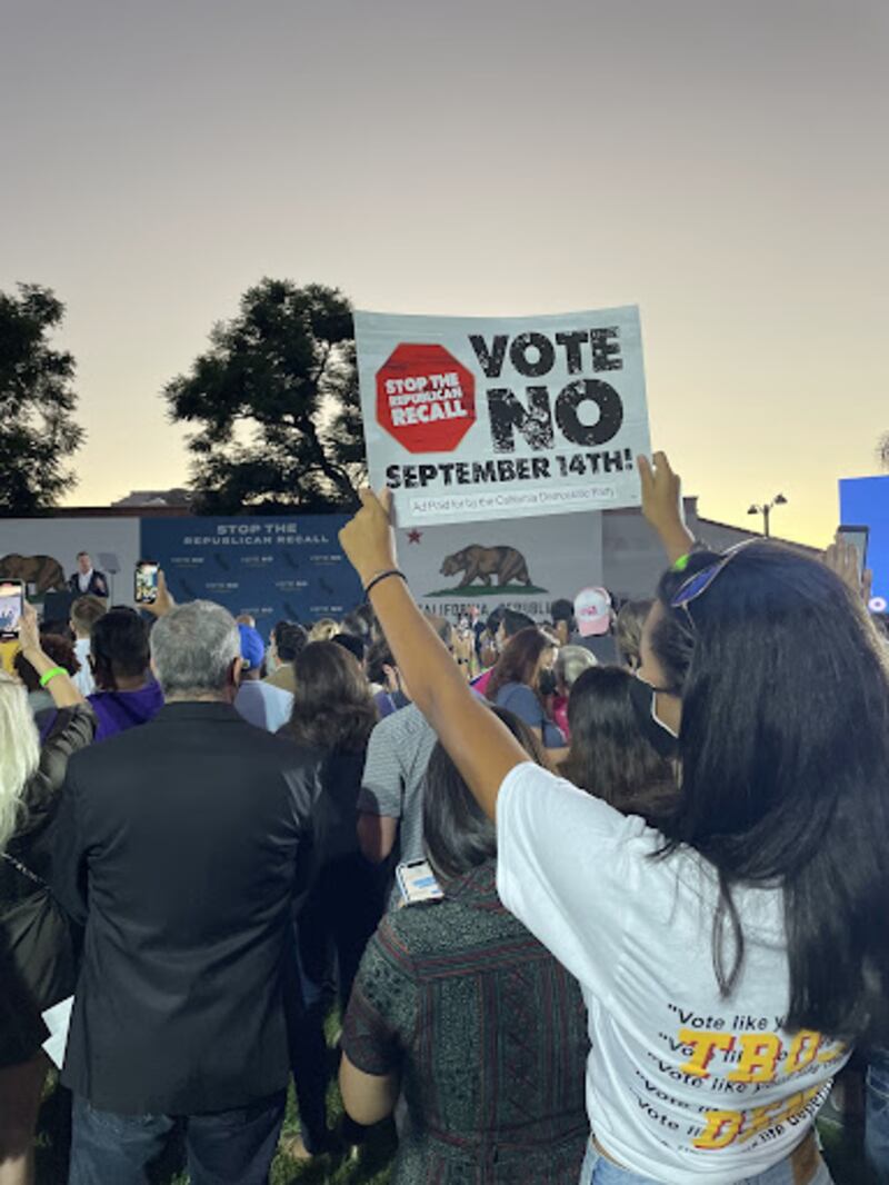 A photo of a young women holding a sign at a protest.