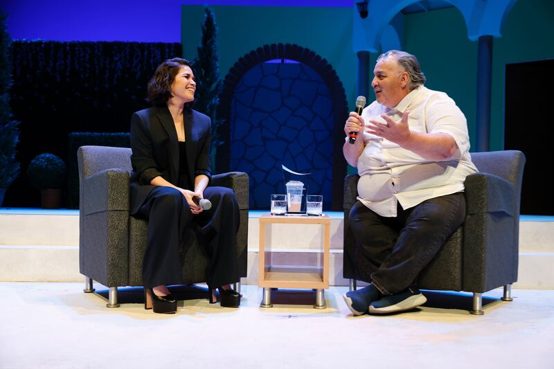 A photo of America Ferrera and Luis Alfaro sitting on stage and speaking to each other.