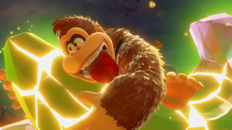 A screenshot from Donkey Kong Bananza, of Donkey Kong hugging a giant banana