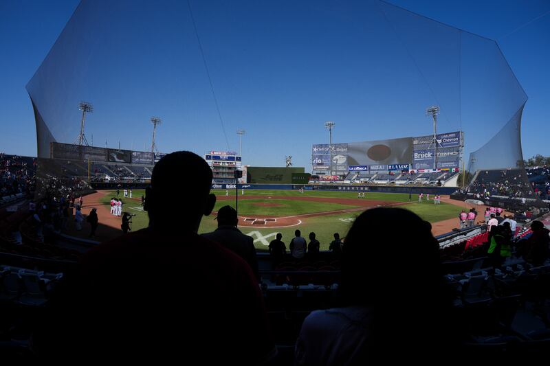 Photo of silhouettes of baseball game attendees.