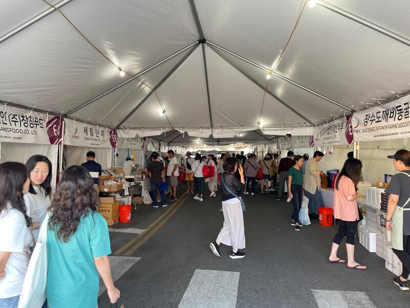 Photo of a long white tent with booths on each side