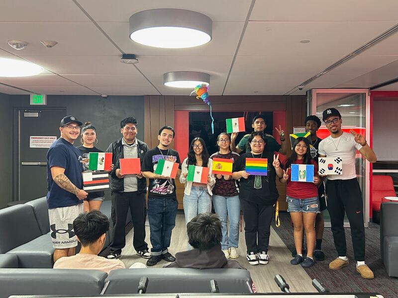 Photo of 11 students holding up paintings of various flags.