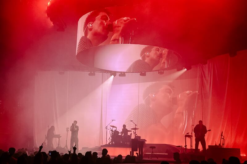 A large projector illuminated with red light on stage at a concert