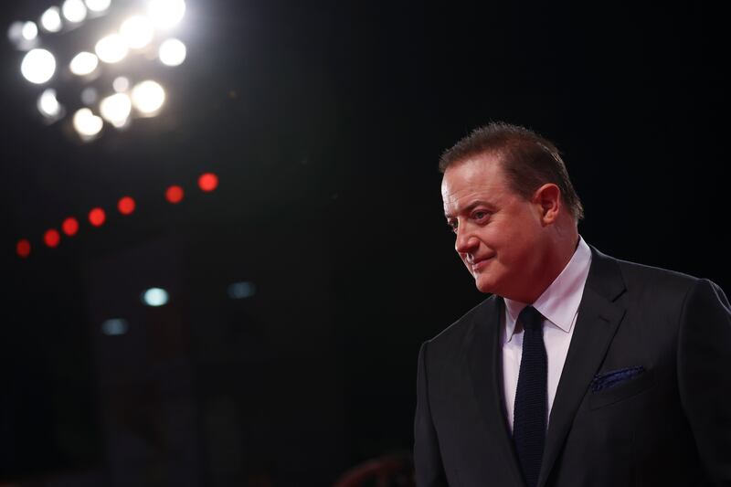 A man at a suit under spotlights