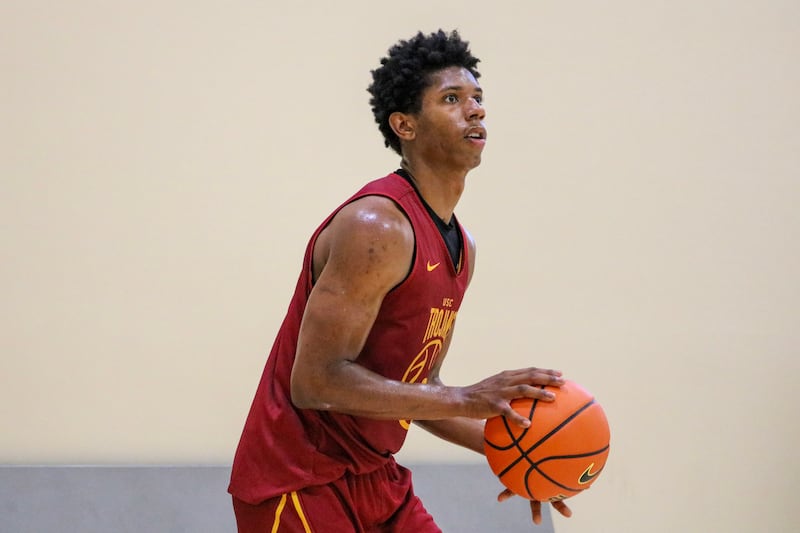 Jerry Easter II (8) in profile with a basketball in his hands as if ready to shoot the ball. He wears a cardinal USC basketball practice jersey with gold accents.