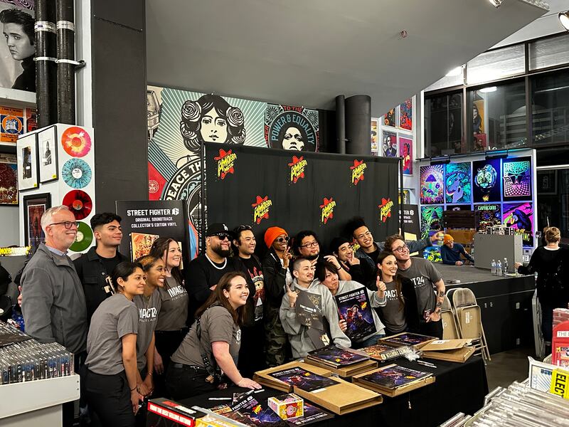 A group of people posing together in front of a stack of posters