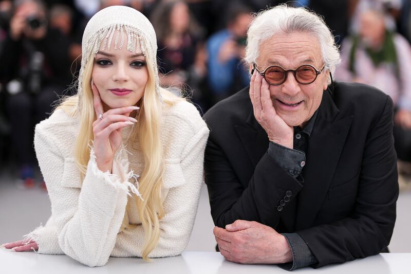 Photo of a woman and a man in front of a large crowd