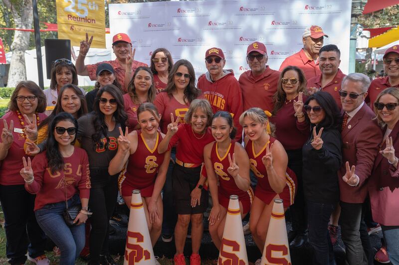 Photo of the President of the University of Southern California with students and staff.