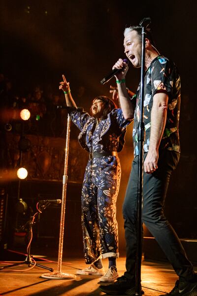 A photo of Fitzgerald and Scaggs singing together on stage.
