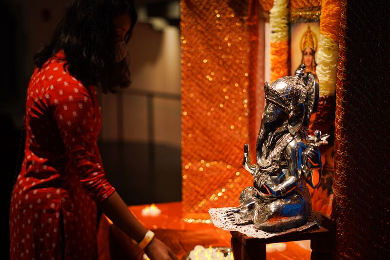 A member of the Hindu Student Organization (HSO) sets up a shrine with the idol of Ganesha—an elephant-headed Hindu god.