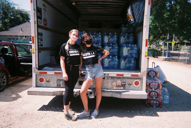 Catie Cummings and Aria Catano standing by the U-Haul