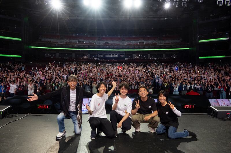People on stage taking a picture in front of a crowd