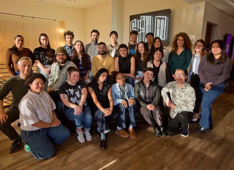 Large group of smiling people in a house.