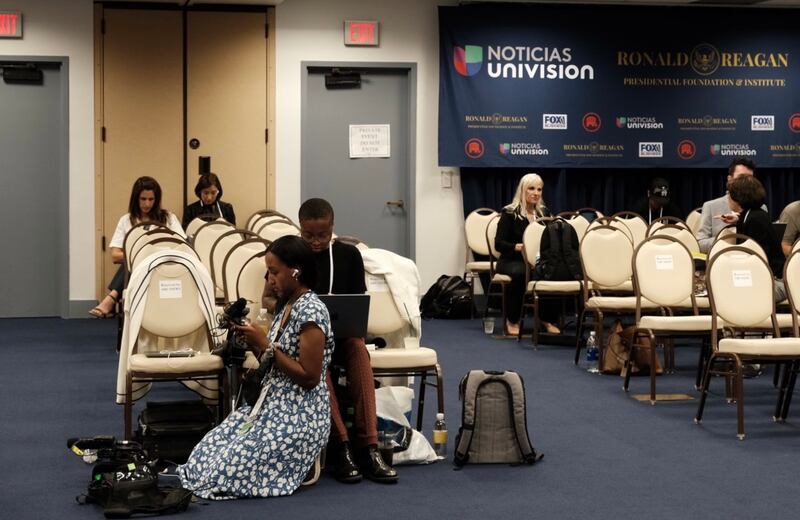 ABC reporters review their footage in the media spin room.