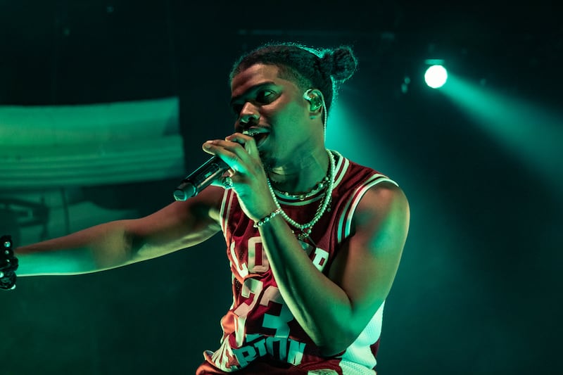 A photo of Smino singing and looking at the audience.