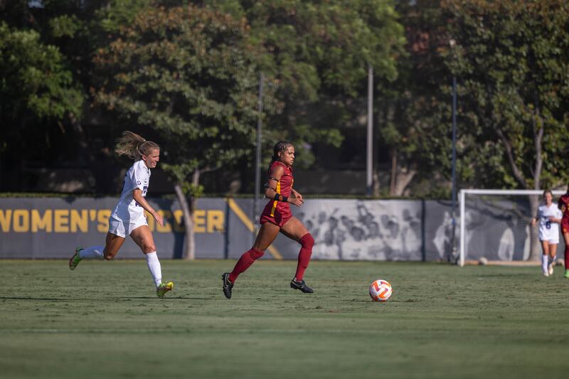 [Croix Bethune dribbles the ball past a TCU player at Soni McAllister field.]