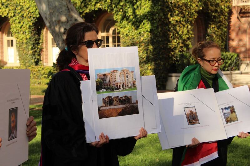 Sarah Gualtieri, a Middle East Studies professor at Dornsife, holds up a picture of Al-Azhar University before and after Israeli Bombing. To the right, Lan Duong, Cinema and Media studies professor at SCA, holds up pictures of Nasser al-Yafawi and Dr. Sharif Al-Asali.