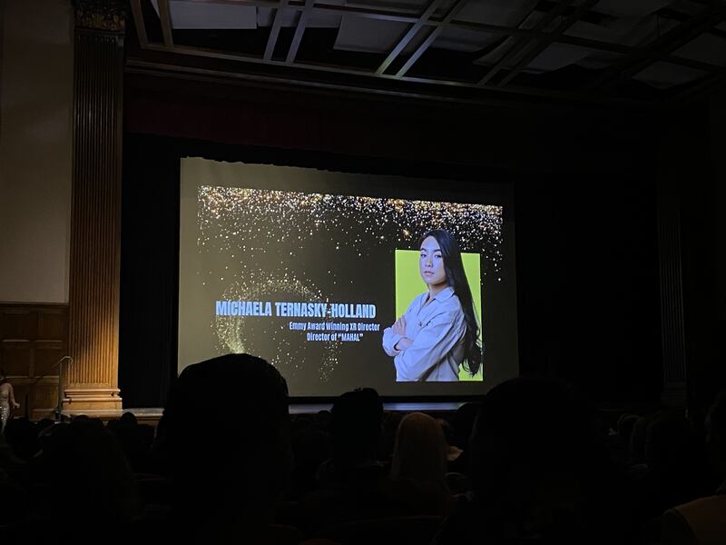 A woman projected on a screen at a film festival.