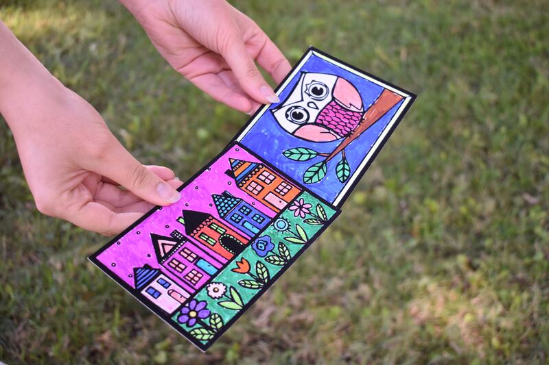 The USC student shows her colored pages of houses and an owl.