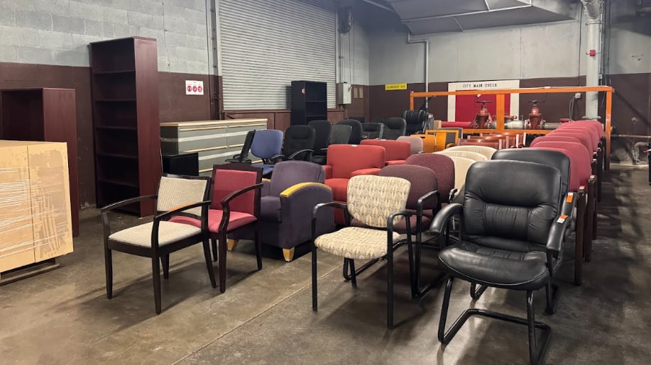 There are three rows of mismatched chairs. Most look slightly worn.