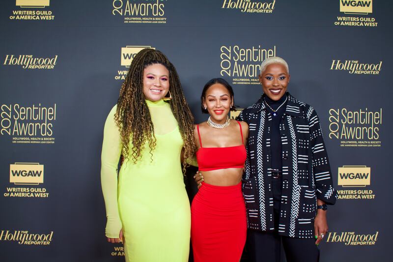 A photo of Oliver, Good and Johnson smiling and posing on the red carpet.