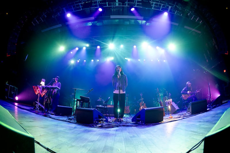 Band plays music on a stage with lights