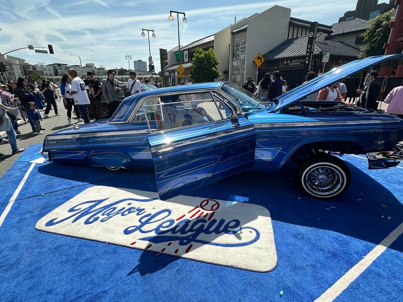 A Dodger's-blue lowrider is on display with a mat under it that reads "Major League" in the Dodger's font