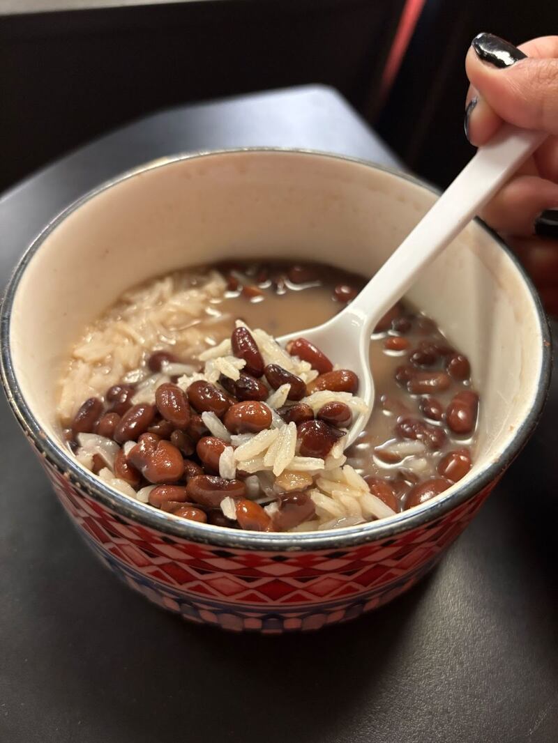 Photo of rice and beans in a colorful bowl with a spoon.