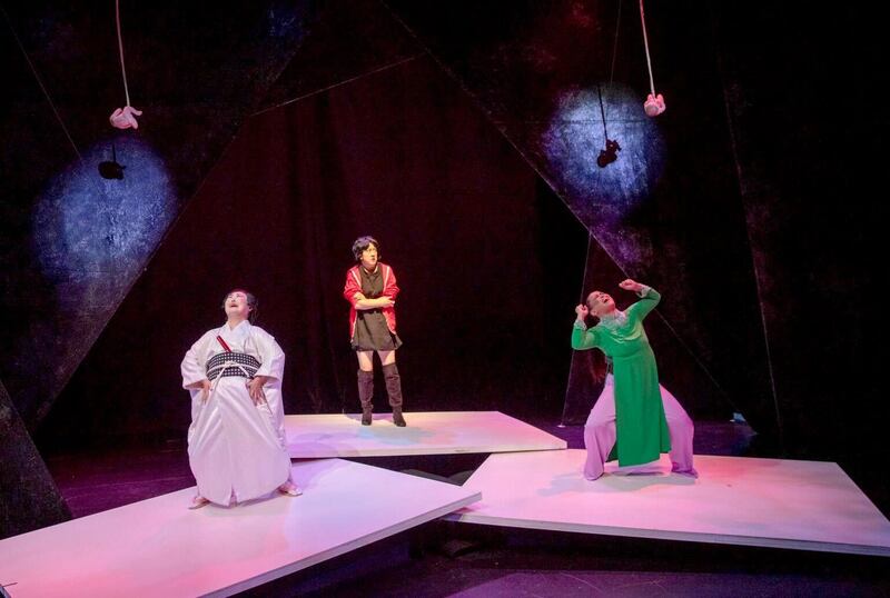 A photo of three women acting on stage in a play.
