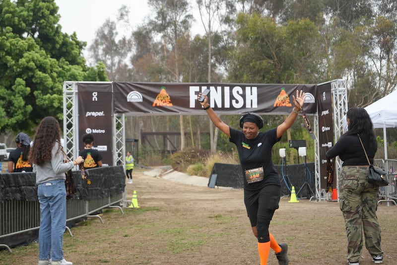 A participant celebrates while crossing the finish line at WalkGood LA’s People’s Pace 5K in Los Angeles on Sept. 21, 2025.