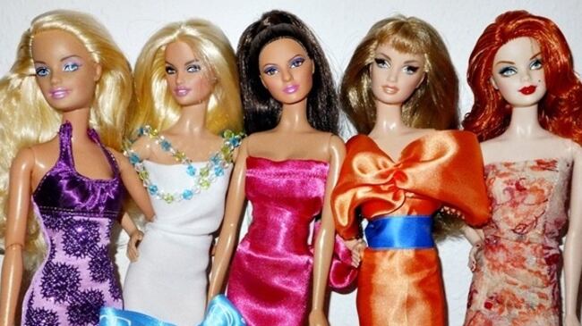 Various Barbies posed in a line wearing different dresses