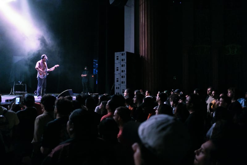 Stage watches a guitarist on stage