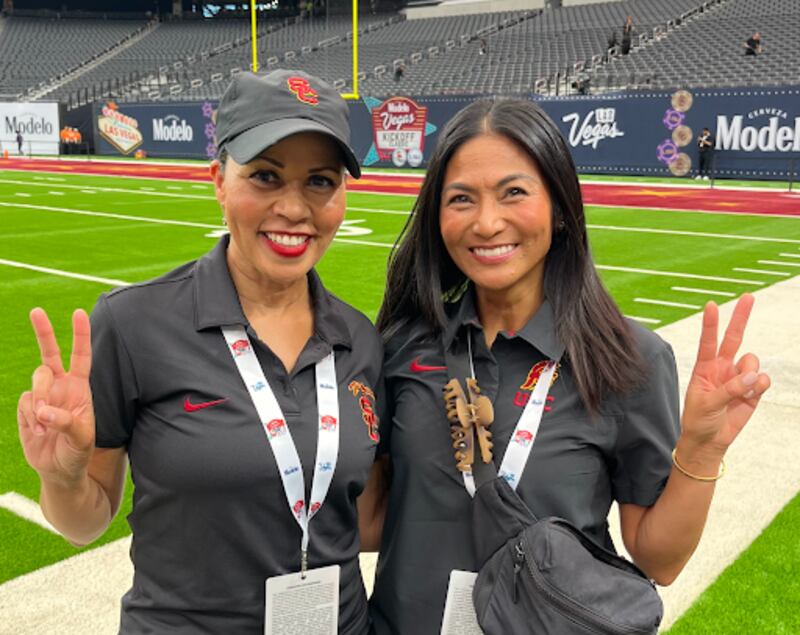 A picture of Audrea Harris, the Song Advisor and Cheryl Azurin, the Song Coach, are pictured giving the USC "fight on" sign